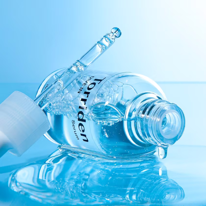 Open bottle and dropper with serum texture.