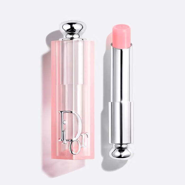 Dior Addict Lip Glow 001 Pink balm beside its pale pink Dior cap