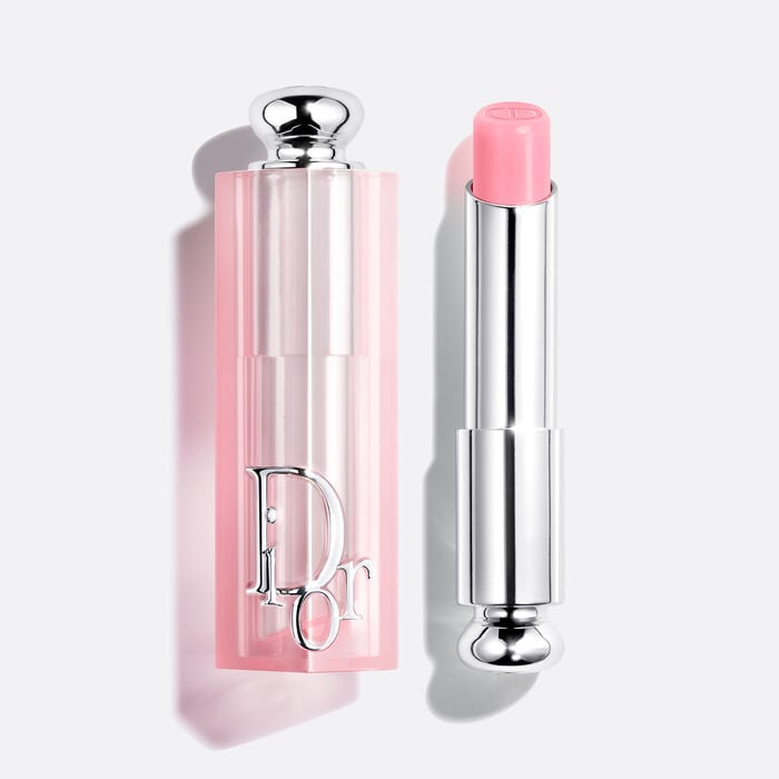 Dior Addict Lip Glow 001 Pink balm beside its pale pink Dior cap