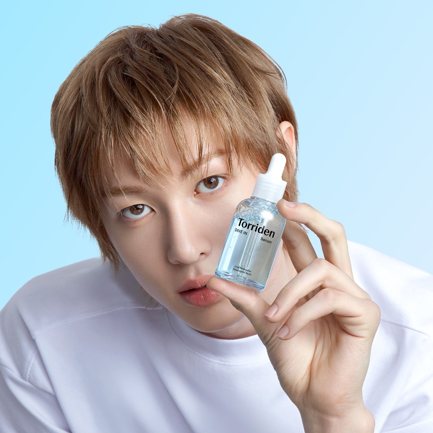 Official model portrait holding DIVE IN Serum.
