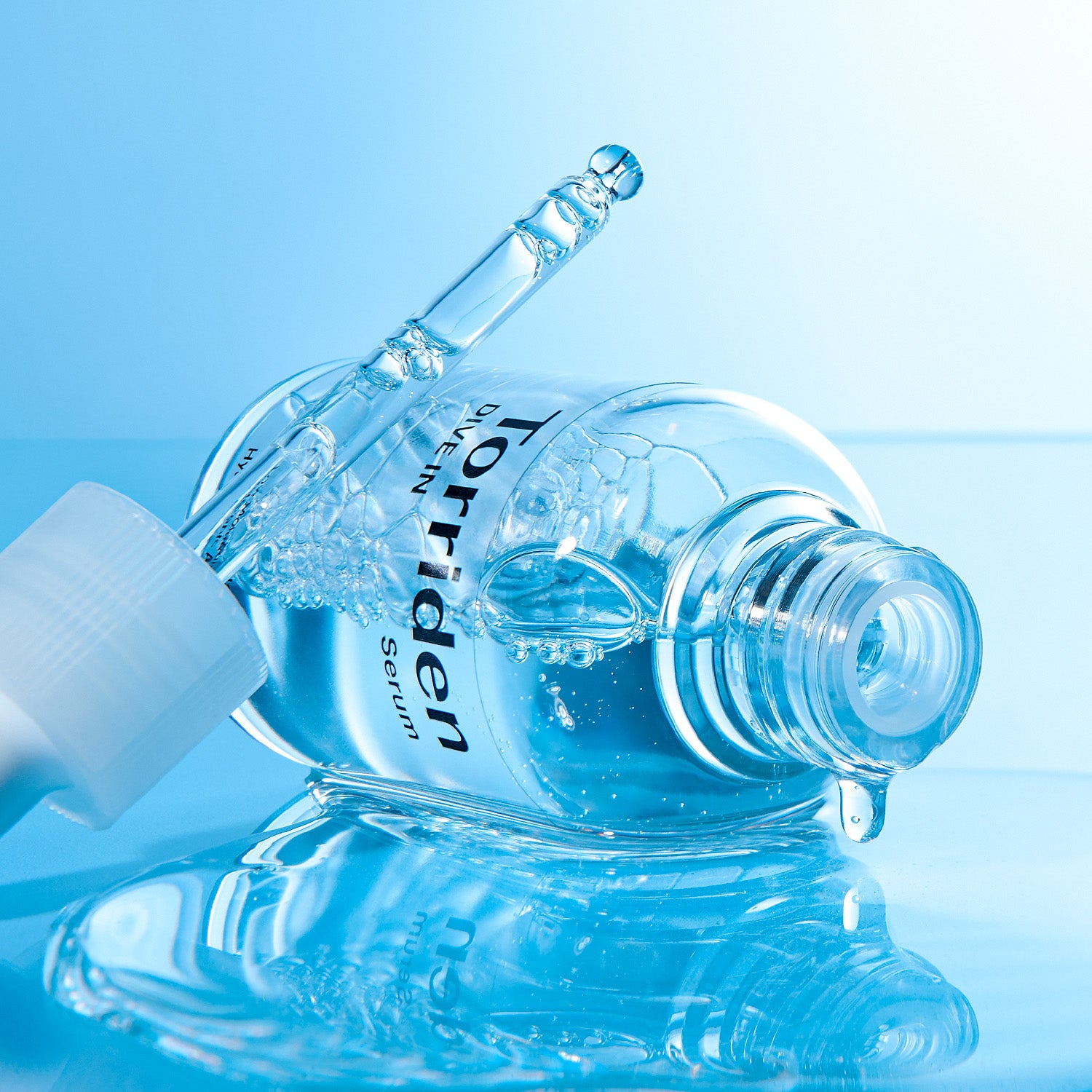 Open bottle and dropper with serum texture.