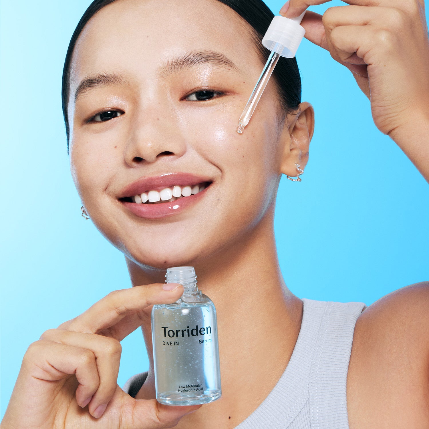 Model applying the serum to the cheek.